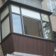 Балкон с ламинированными окнами и отделкой.
